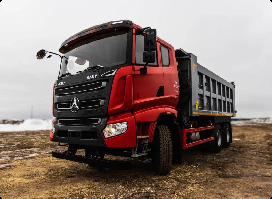 Красный самосвал Sany SYZ320C-8S стоит на грунтовой дороге в горах