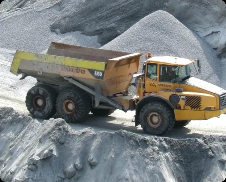 Желтый самосвал Volvo A350 едет по грунтовой дороге